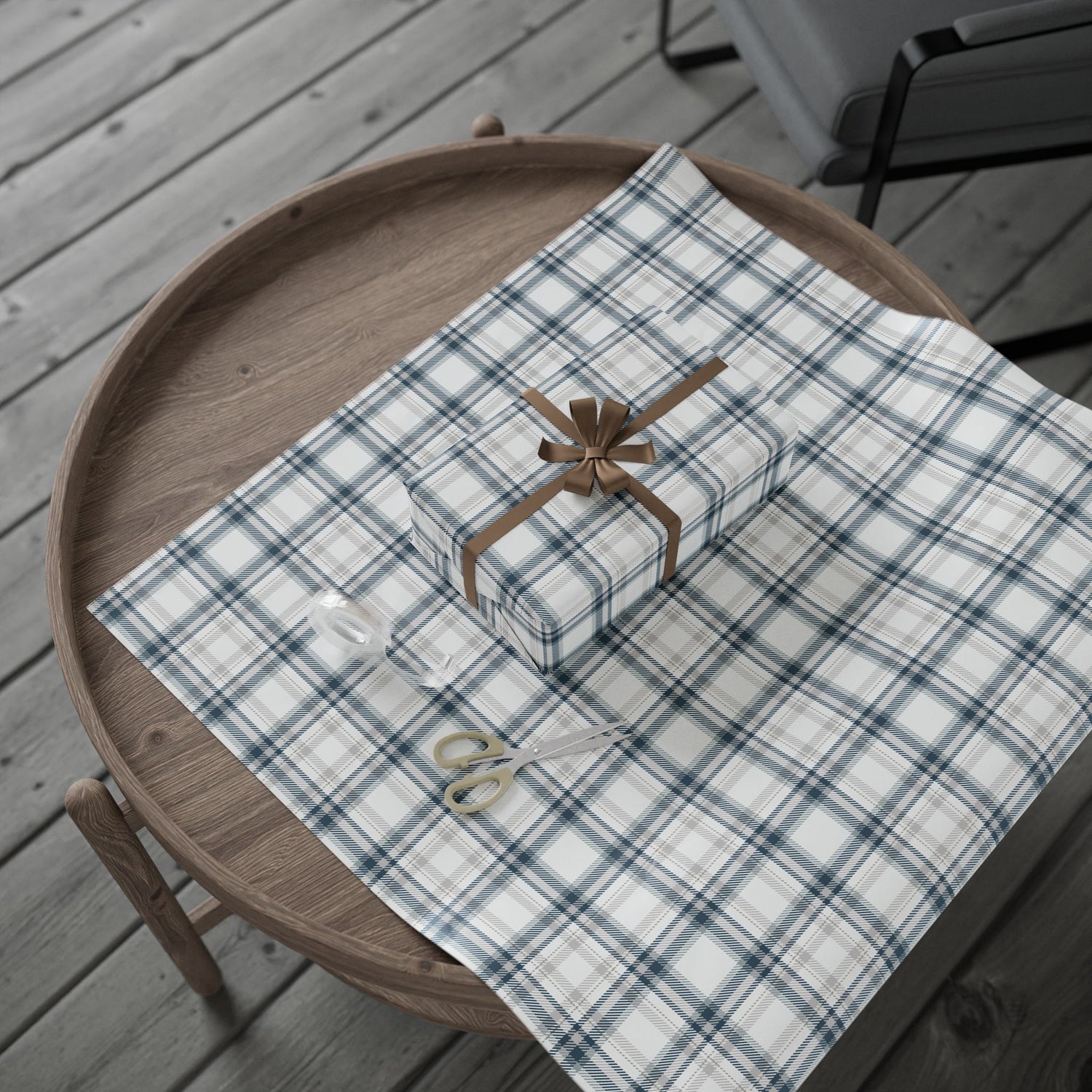 Plaid tablecloth with a gift box and scissors on a wooden tray