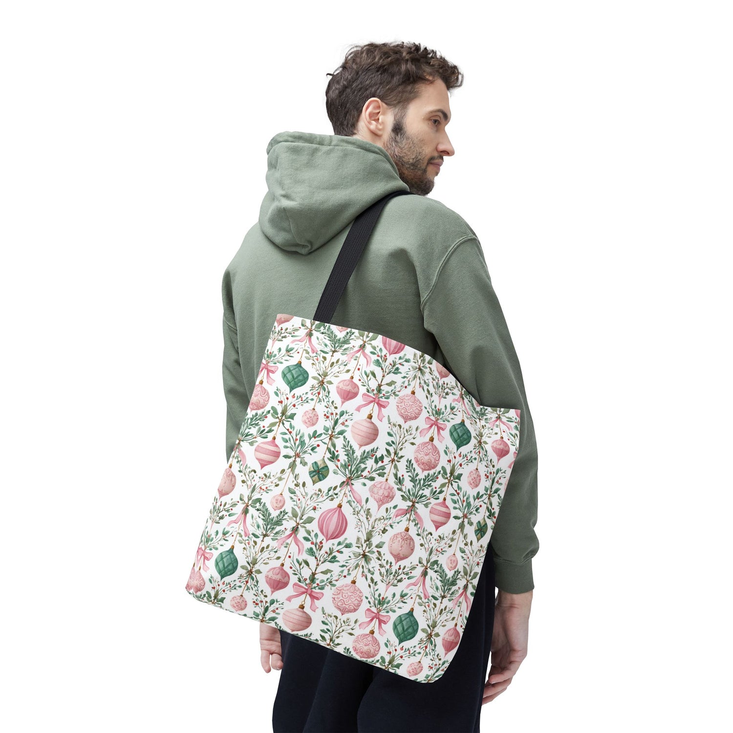 Man wearing a green hoodie with a floral-patterned tote bag on a white background