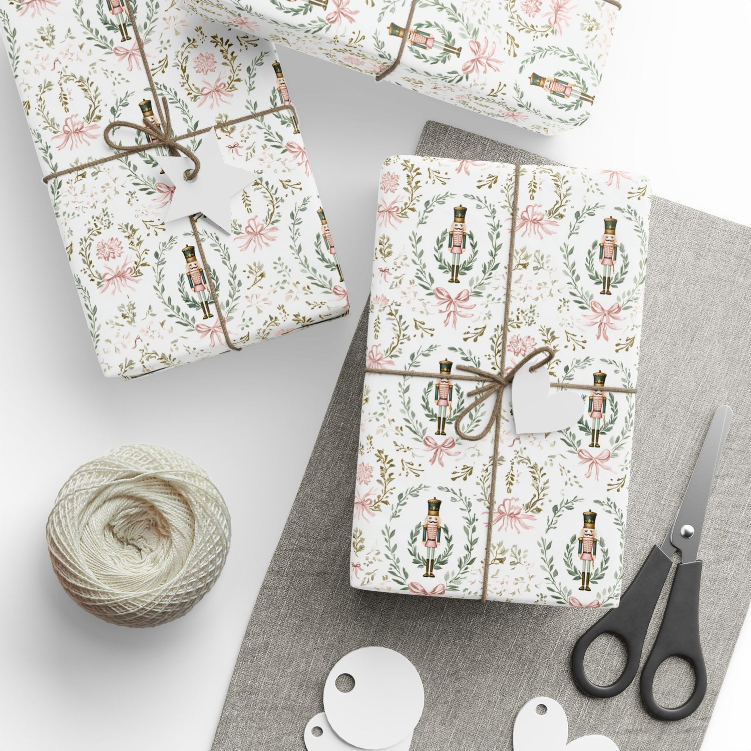 Gift boxes wrapped in festive paper with scissors and yarn on a light surface