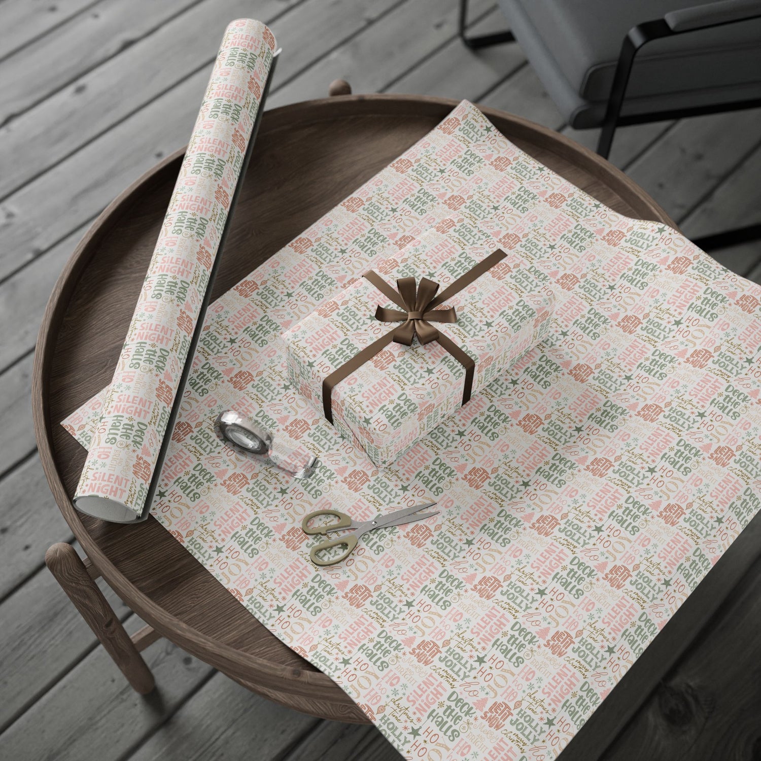 Gift wrap with text and a roll of paper on a wooden table.