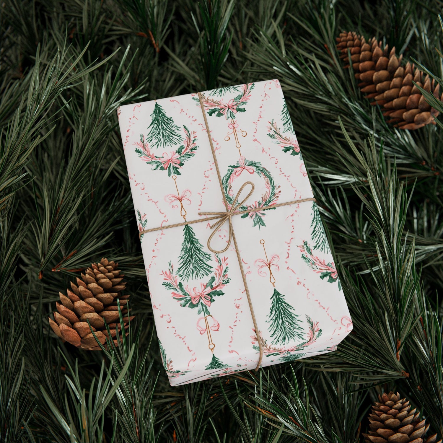 Gift wrapped in festive paper with pine cones and greenery