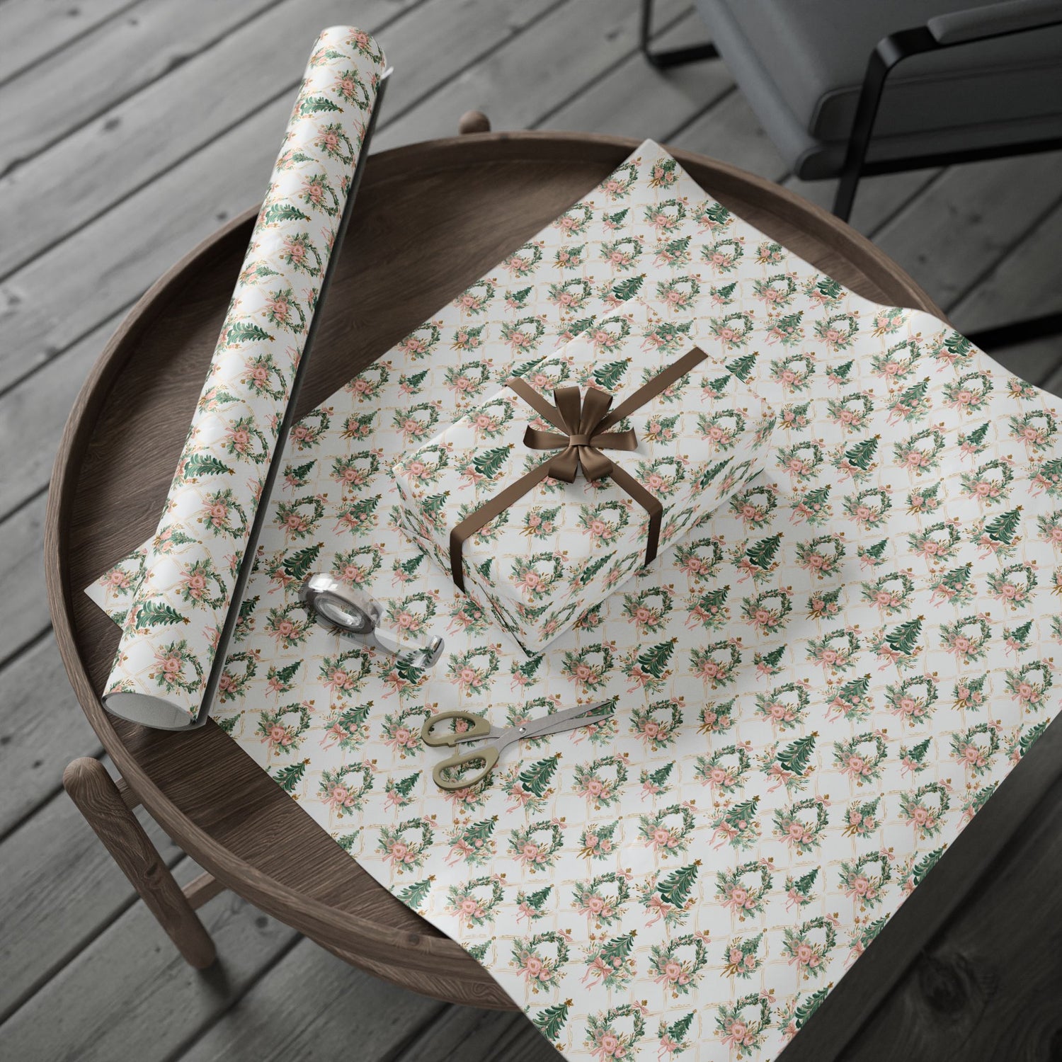 Roll of floral-patterned paper on a wooden tray with scissors on a wooden surface.