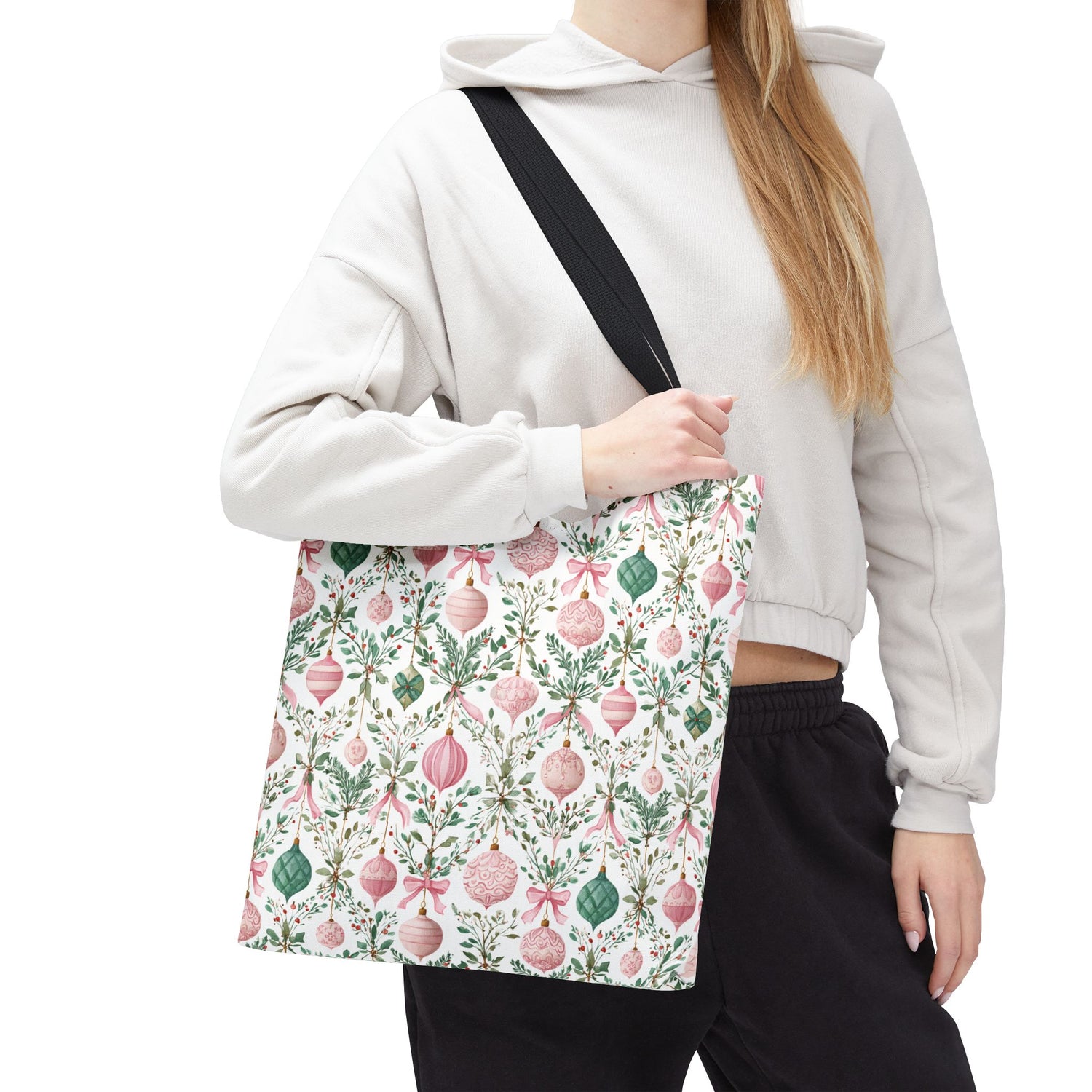 Person wearing a white hoodie with a floral-patterned bag over their shoulder on a white background