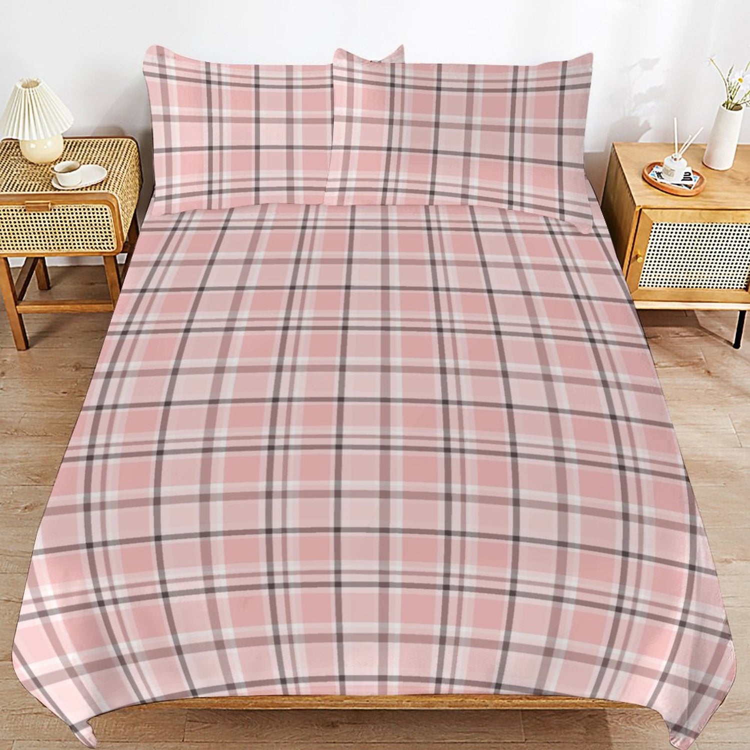 Pink plaid bedspread on a bed with matching pillows in a bedroom setting.